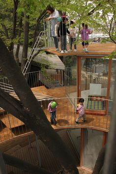 two children are standing on the top floors of a tree house