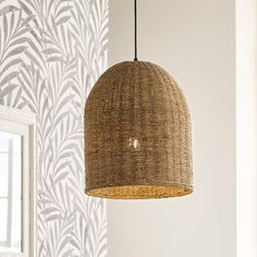 a light fixture hanging from a ceiling in a room with wallpaper and a mirror