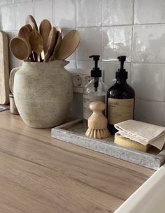 a bathroom counter with wooden utensils and soap dispensers