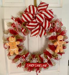 a christmas wreath with gingerbreads and candy canes hanging on the front door