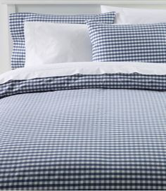 a blue and white checkered comforter set on a bed with two pillow cases