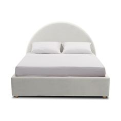 a white bed with two pillows on top of it and a night stand underneath the headboard