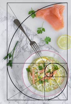 a white plate topped with fish next to a bowl of rice and garnish