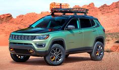 a green jeep parked in the desert with its roof rack on it's top