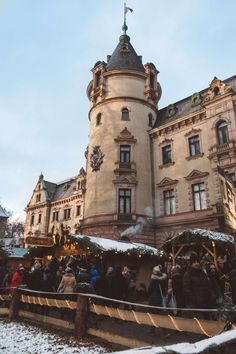 people are standing in front of an old building with christmas decorations on the outside and inside