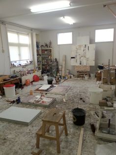 an empty room with various items on the floor and shelves full of paintbrushes