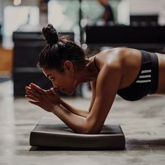 a woman doing push ups on a yoga mat