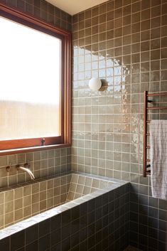 a bath tub sitting next to a window in a bathroom