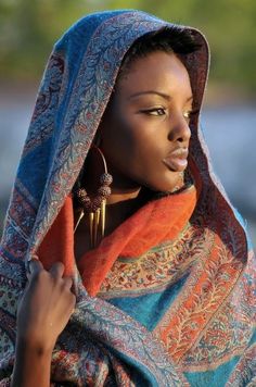 an african woman wearing earrings and a shawl