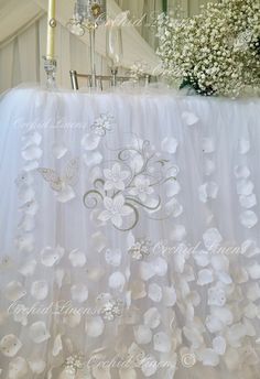 a white table with flowers and candles on it