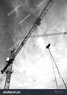 black and white photo of crane against cloudy sky