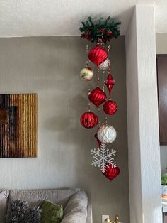 a living room decorated for christmas with ornaments hanging from the ceiling