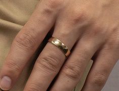 a woman's hand with a gold ring on it