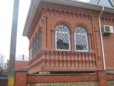 a red brick building with two windows on the side