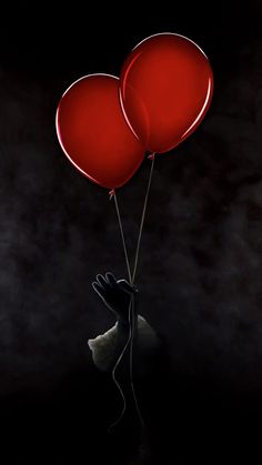 two red balloons floating in the air on top of a black background with text that reads,