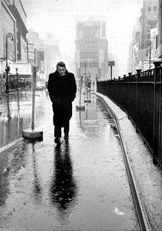 a man walking down a street in the rain