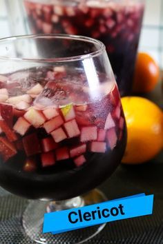 two glasses filled with liquid and fruit on top of a table