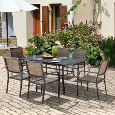 an outdoor dining table with chairs and umbrella