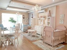 a baby's room with pink walls, white furniture and chandelier hanging from the ceiling