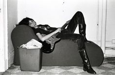 a man laying on top of a couch holding an electric guitar