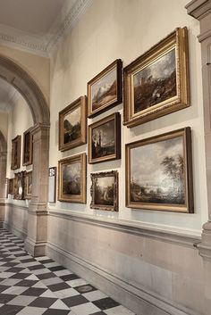 a hallway with paintings on the wall and checkered floor