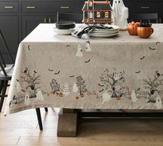 a dining room table decorated for halloween with ghostes and pumpkins
