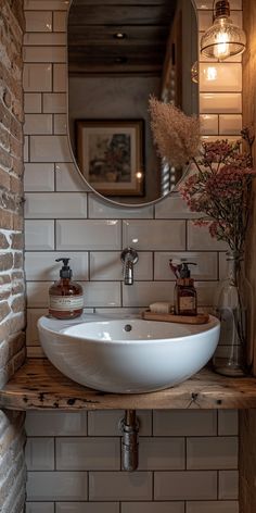 a bathroom sink sitting under a mirror next to a wooden shelf with flowers on it