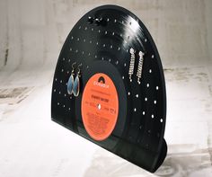 a record shaped clock with earrings on it