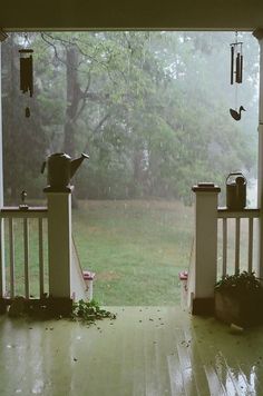 an open porch door with rain falling on it and the words sitting on the porch watching the rain