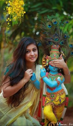 a woman holding a peacock statue in front of her face