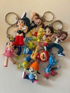 a bunch of key chains that are shaped like cartoon characters