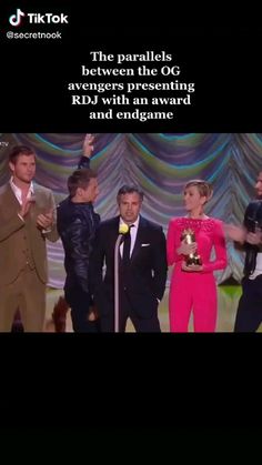 the panelists between the oc and avengers presenting rdj with an award and endgame