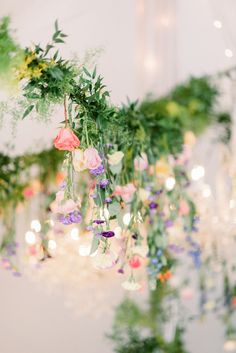 flowers and greenery are hanging from the ceiling