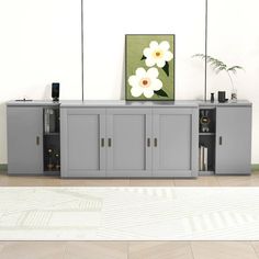 an entertainment center with grey cabinets and white flowers