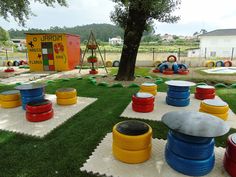 an outdoor play area with colorful plastic barrels
