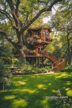 a tree house in the middle of a lush green field with stairs leading up to it