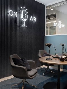 a table with two chairs and microphones in front of a sign that says on air