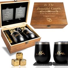 two black wine glasses in a wooden box with matching gold flasks next to it