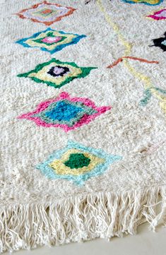 a multicolored rug with fringes on the floor