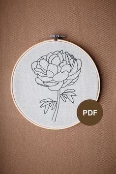 the embroidery pattern shows a large flower in black and white, on a beige background