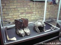 two pairs of shoes are on display in a glass case next to a brick wall