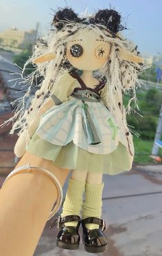 a hand holding a doll with long hair