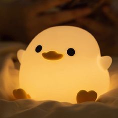 a white light that is shaped like a duck with black eyes and an orange beak
