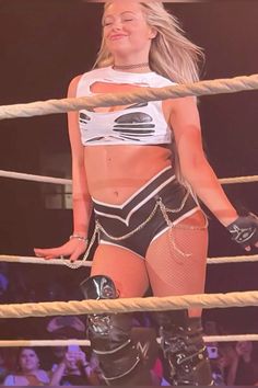 a female wrestler is standing in the ring