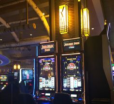 several slot machines in a casino with neon lights