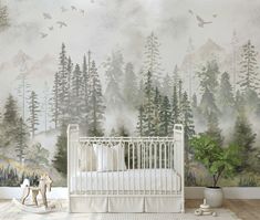 a white crib in front of a forest mural