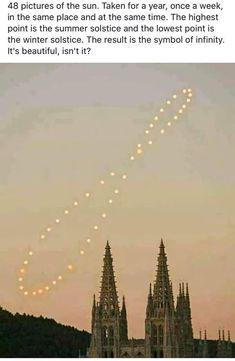 an airplane flying in the sky over a city with lights on it's spires