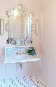 a bathroom vanity with a mirror above it and flowers in a vase on the sink