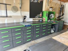 a garage with lots of drawers and tools on the counter top in front of it