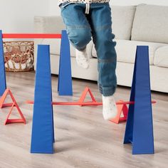 a child is jumping over obstacles in the living room